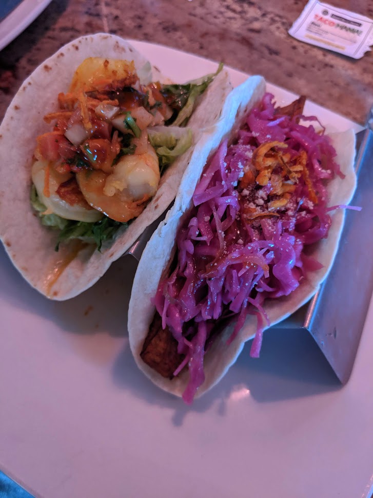 Two tacos from Blend on a metal serving rack.