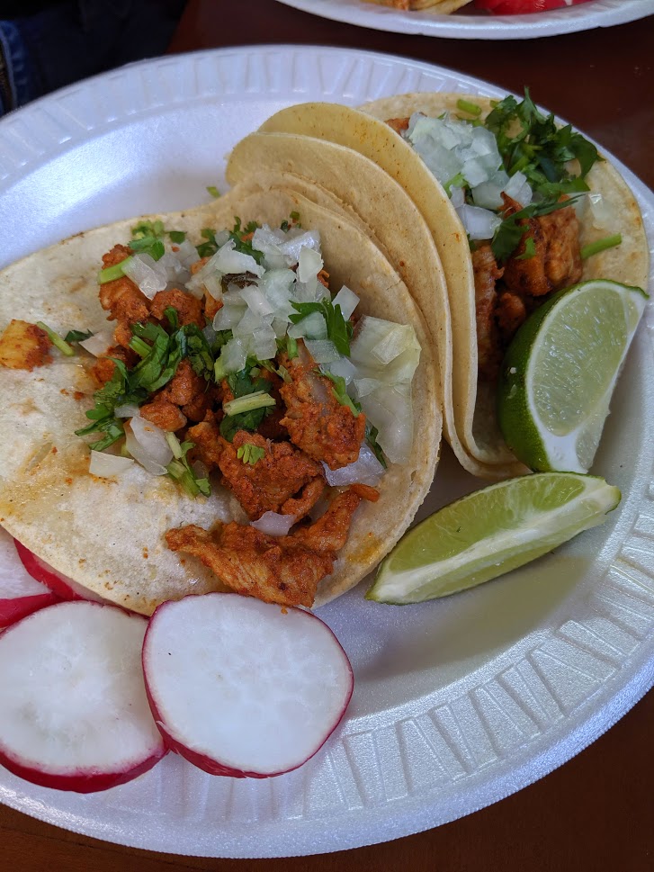 Two tacos from La Mexicana with a side of lime.