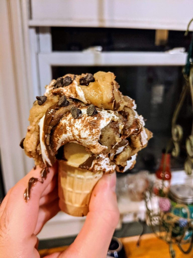 Cookie dough with chocolate chips and Nutella and marshmallow fluff swirls on an ice cream cone.
