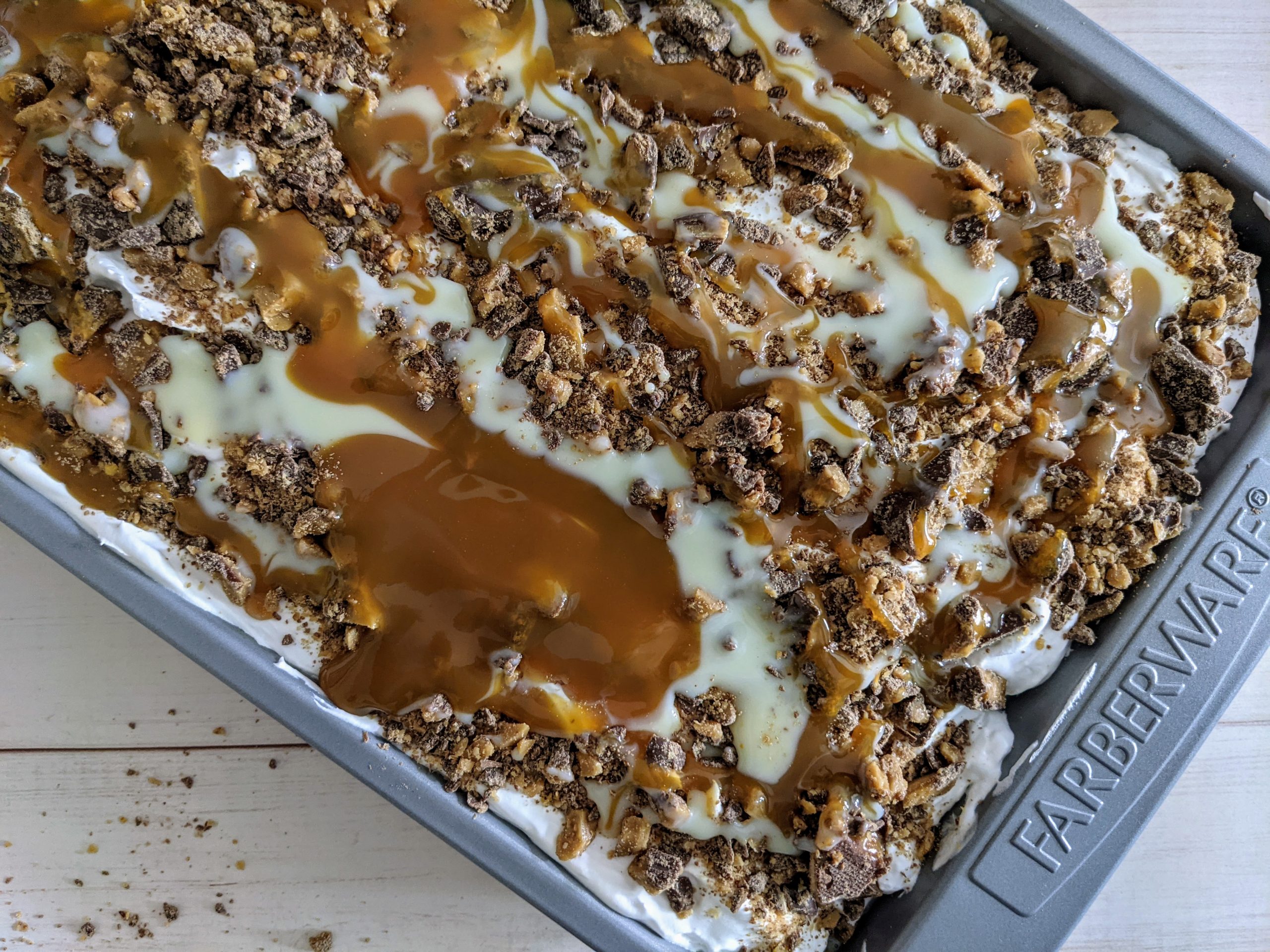 Birds eye view of finished heath bar cake topped with caramel and sweetened condensed milk drizzle.