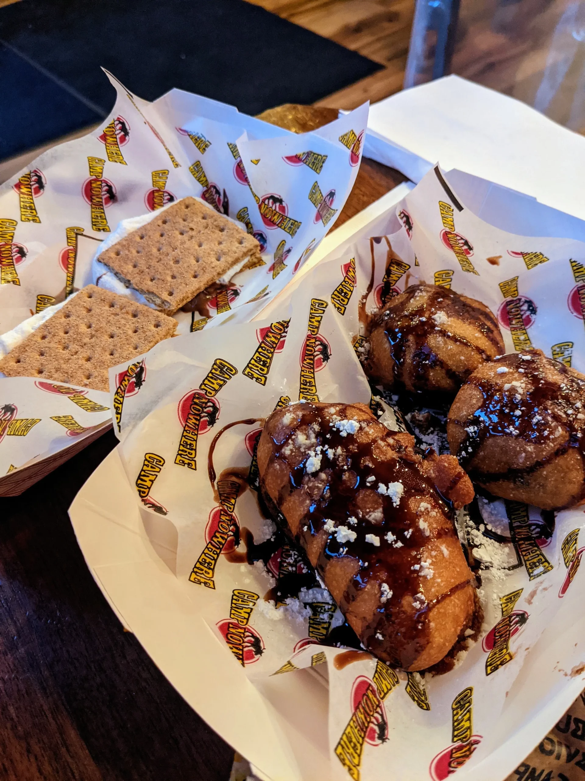 S'mores, fried twinkies and fried Oreos in a food casket sit on a wooden table at Camp Nowhere.