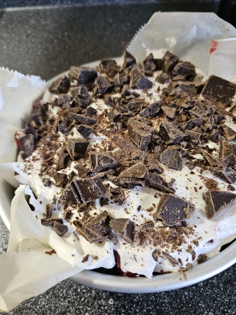 Side view of black forest poke cake in an 8x8 round pan.
