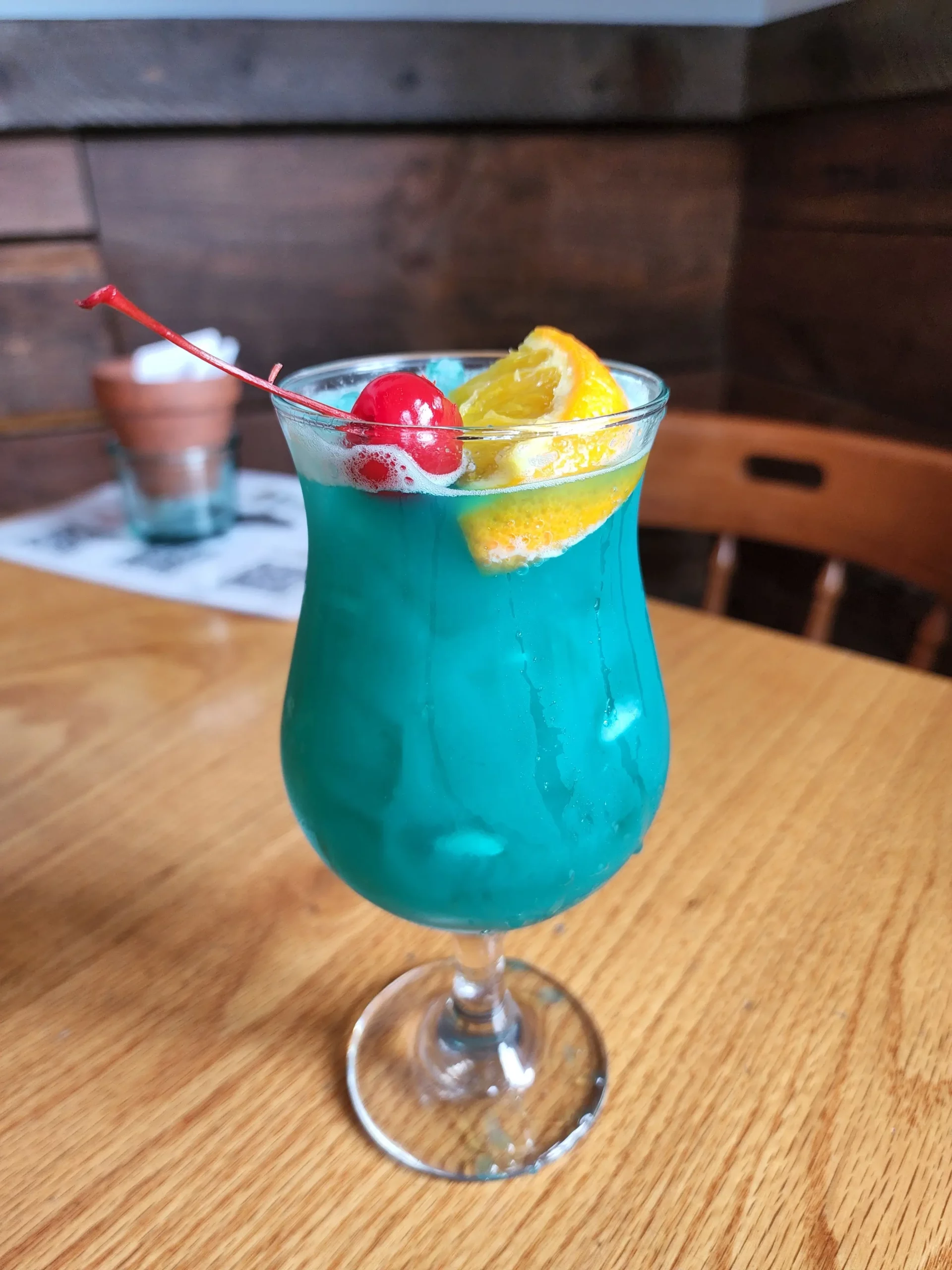 A light blue cocktail from Malted Barley placed on a table.