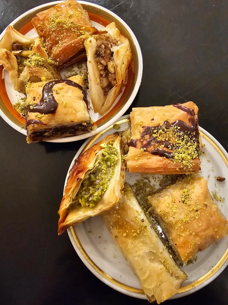 Multiple pieces of baklava on plates from Providence Rhode Island's Aleppo Sweets.
