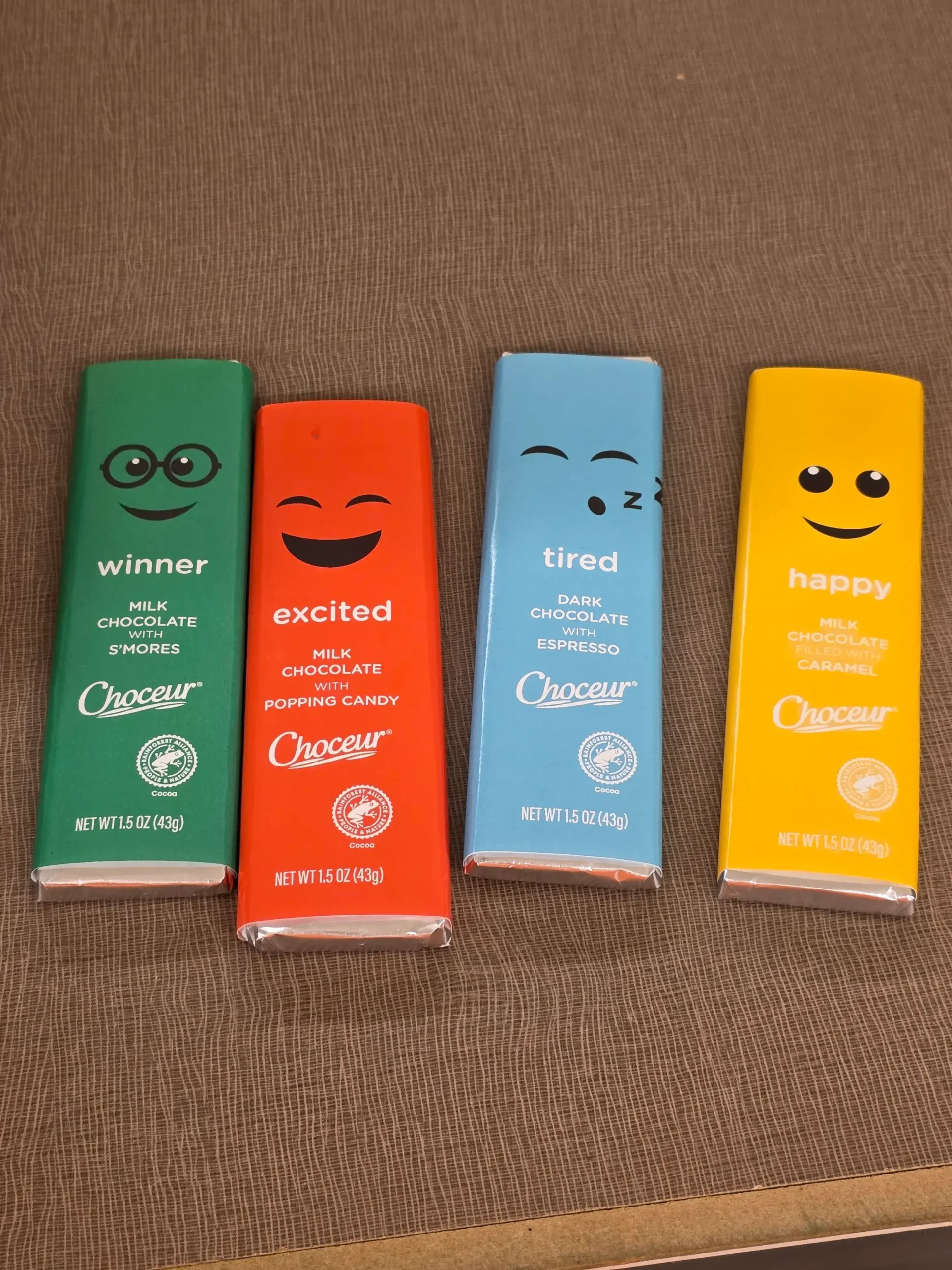 Aldi Choceur Mood Chocolate Bars: Happy (Milk Chocolate Filled With Caramel), Tired (Dark Chocolate With Espresso), Excited (Milk Chocolate With Popping Candy), and Winner (Milk Chocolate With S'mores).