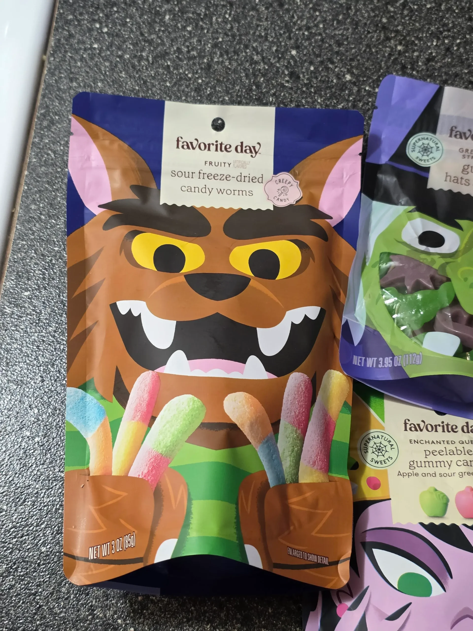 Target Favorite Day Halloween Gummy Candy: Enchanted Queen Peelable Apple & Sour Green Apple, Witch Hats and Wands, Halloween Monster Bash Peelable Fruity, Strawberry Gummy Candy Brains, and Fruity Sour Freeze-Dried Candy Worms.