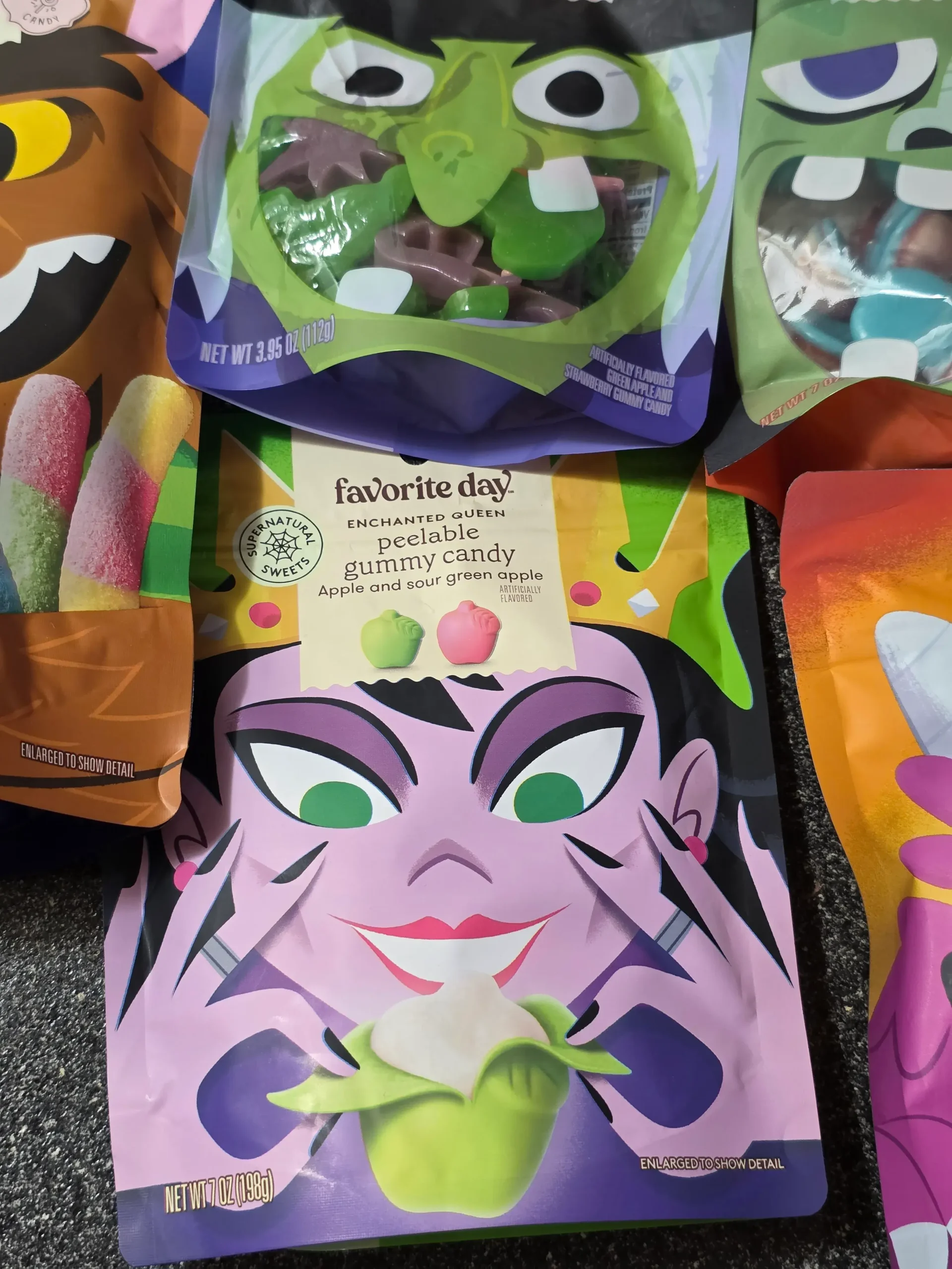 Target Favorite Day Halloween Gummy Candy: Enchanted Queen Peelable Apple & Sour Green Apple, Witch Hats and Wands, Halloween Monster Bash Peelable Fruity, Strawberry Gummy Candy Brains, and Fruity Sour Freeze-Dried Candy Worms.