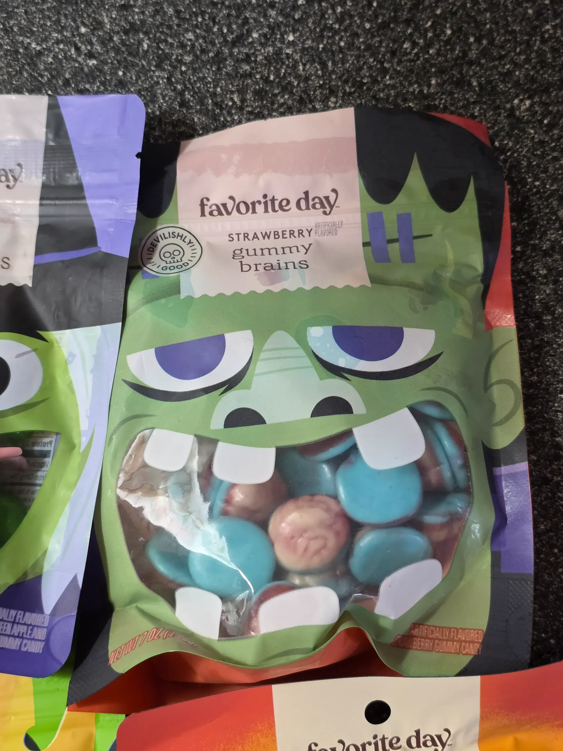 Target Favorite Day Halloween Gummy Candy: Enchanted Queen Peelable Apple & Sour Green Apple, Witch Hats and Wands, Halloween Monster Bash Peelable Fruity, Strawberry Gummy Candy Brains, and Fruity Sour Freeze-Dried Candy Worms.