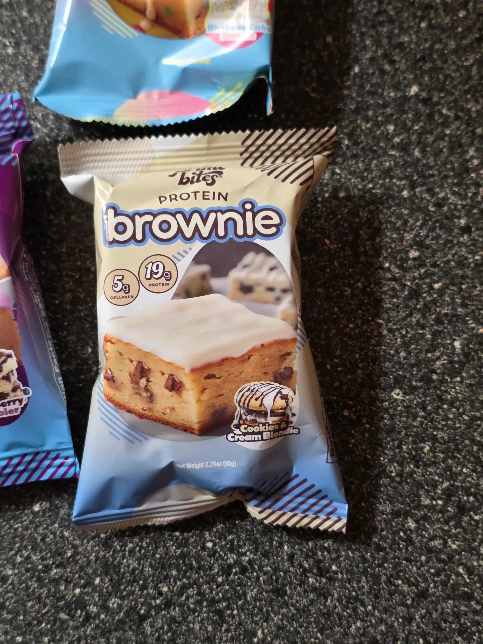 Prime Bites variety pack, including: Chocolate Glazed Donut, Glazed Cinnamon Roll, Birthday Cake, Banana Nut, Peanut Butter Candy Crunch, Chocolate Cookie Monster, Cookie Dough, Blueberry Cobbler, and Cookies & Cream Blondie.