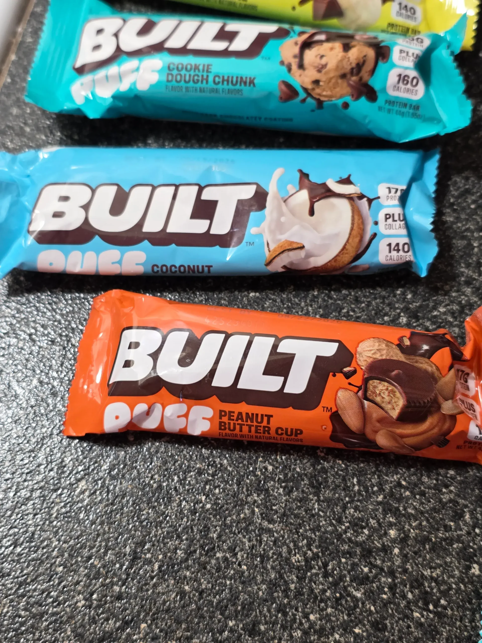 Built Puff Protein Bars: Chocolate Milkshake, Banana Cream Pie, Cookie Dough Chunk, Coconut, Peanut Butter Cup, S'mores Chunk, Brownie Batter, Cookies 'N Cream, Mint Chip, Salted Caramel, and Cookie Dough Chunk.