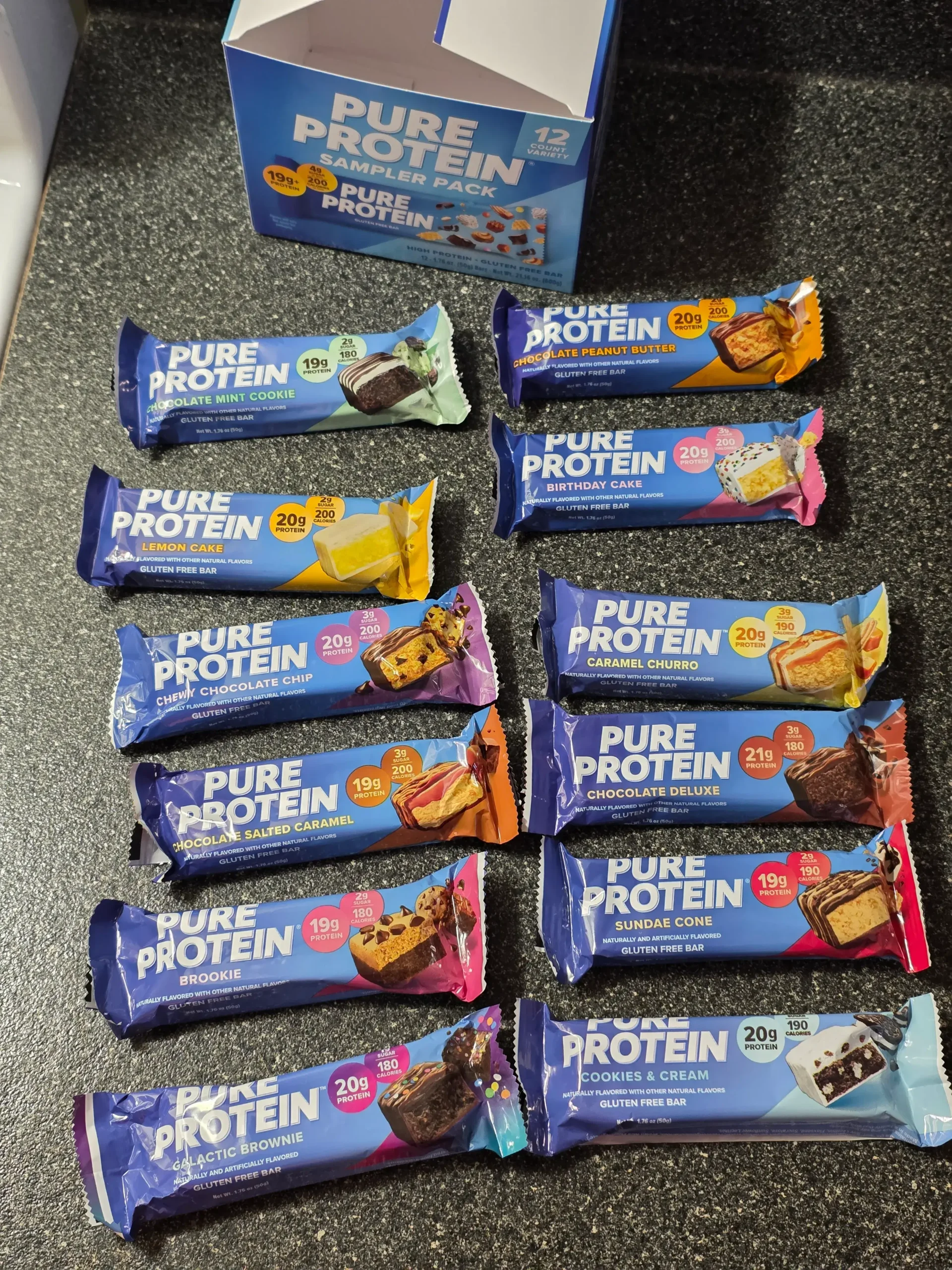 Pure Protein Bar Variety Pack: Chocolate Peanut Butter, Birthday Cake, Caramel Churro, Chocolate Deluxe, Sundae Cone, Cookies & Cream, Galactic Brownie, Brookie, Chocolate Salted Caramel, Chewy Chocolate Chip, Lemon Cake, and Chocolate Mint Cookie.