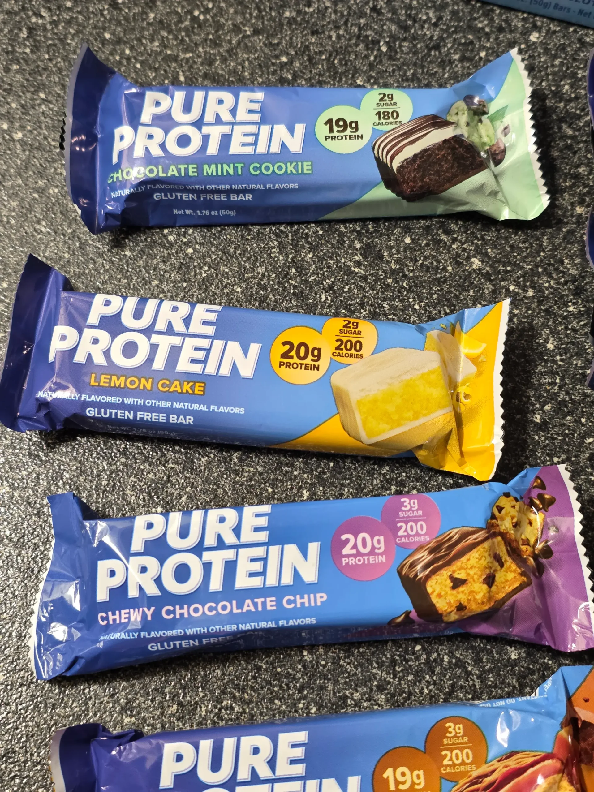 Pure Protein Bar Variety Pack: Chocolate Peanut Butter, Birthday Cake, Caramel Churro, Chocolate Deluxe, Sundae Cone, Cookies & Cream, Galactic Brownie, Brookie, Chocolate Salted Caramel, Chewy Chocolate Chip, Lemon Cake, and Chocolate Mint Cookie.