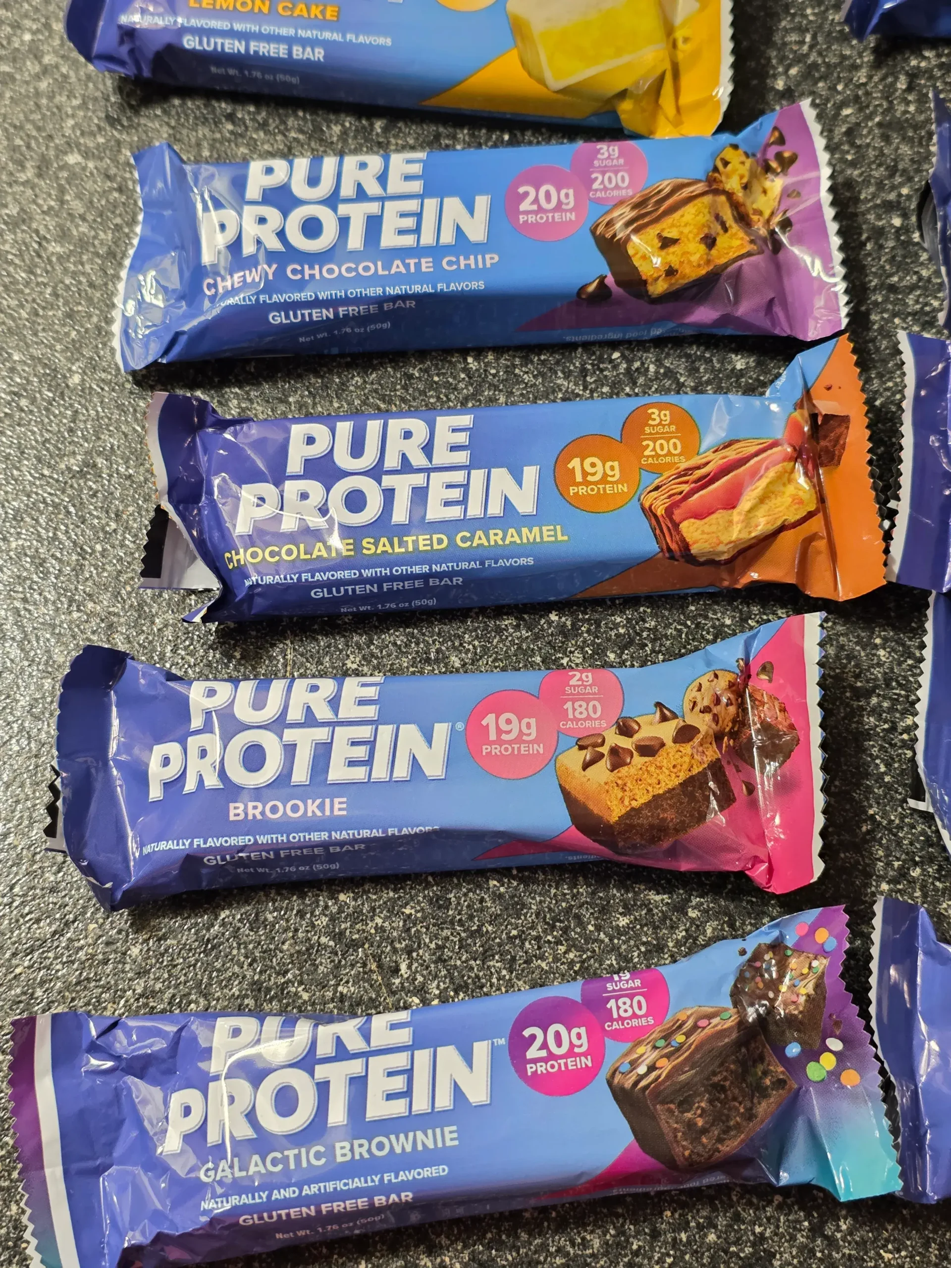 Pure Protein Bar Variety Pack: Chocolate Peanut Butter, Birthday Cake, Caramel Churro, Chocolate Deluxe, Sundae Cone, Cookies & Cream, Galactic Brownie, Brookie, Chocolate Salted Caramel, Chewy Chocolate Chip, Lemon Cake, and Chocolate Mint Cookie.