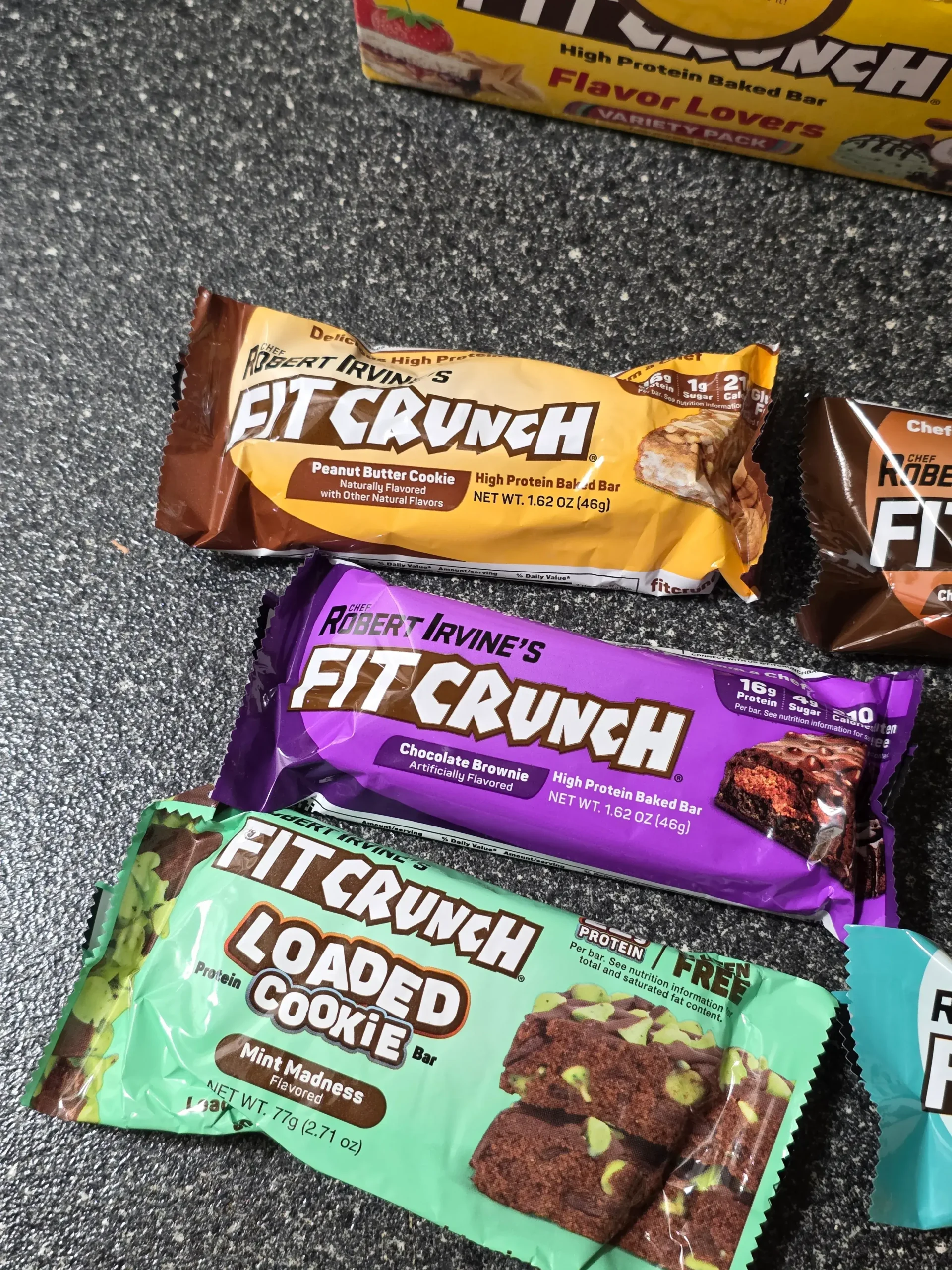 Robert Irvine's FITCRUNCH Protein Bars, including Flavor Lover's Variety pack: Chocolate Peanut Butter, Chocolate Banana, Chocolate Chip Cookie Dough, Chocolate Brownie, Chocolate Coconut Almond, Cinnamon Twist, Milk & Cookies, Lemon Cake, Apple Pie, and Mint Madness Loaded Cookie.