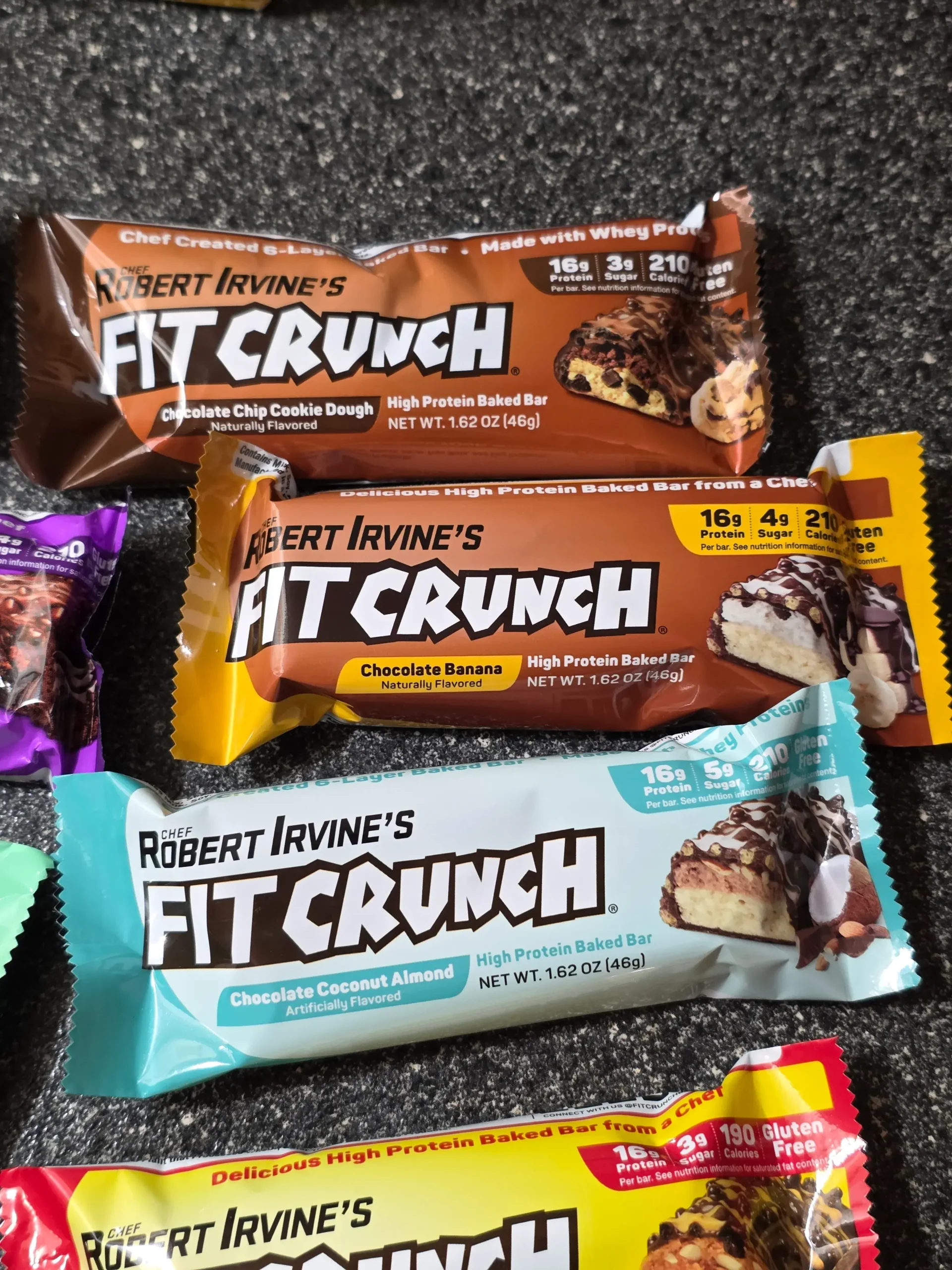 Robert Irvine's FITCRUNCH Protein Bars, including Flavor Lover's Variety pack: Chocolate Peanut Butter, Chocolate Banana, Chocolate Chip Cookie Dough, Chocolate Brownie, Chocolate Coconut Almond, Cinnamon Twist, Milk & Cookies, Lemon Cake, Apple Pie, and Mint Madness Loaded Cookie.