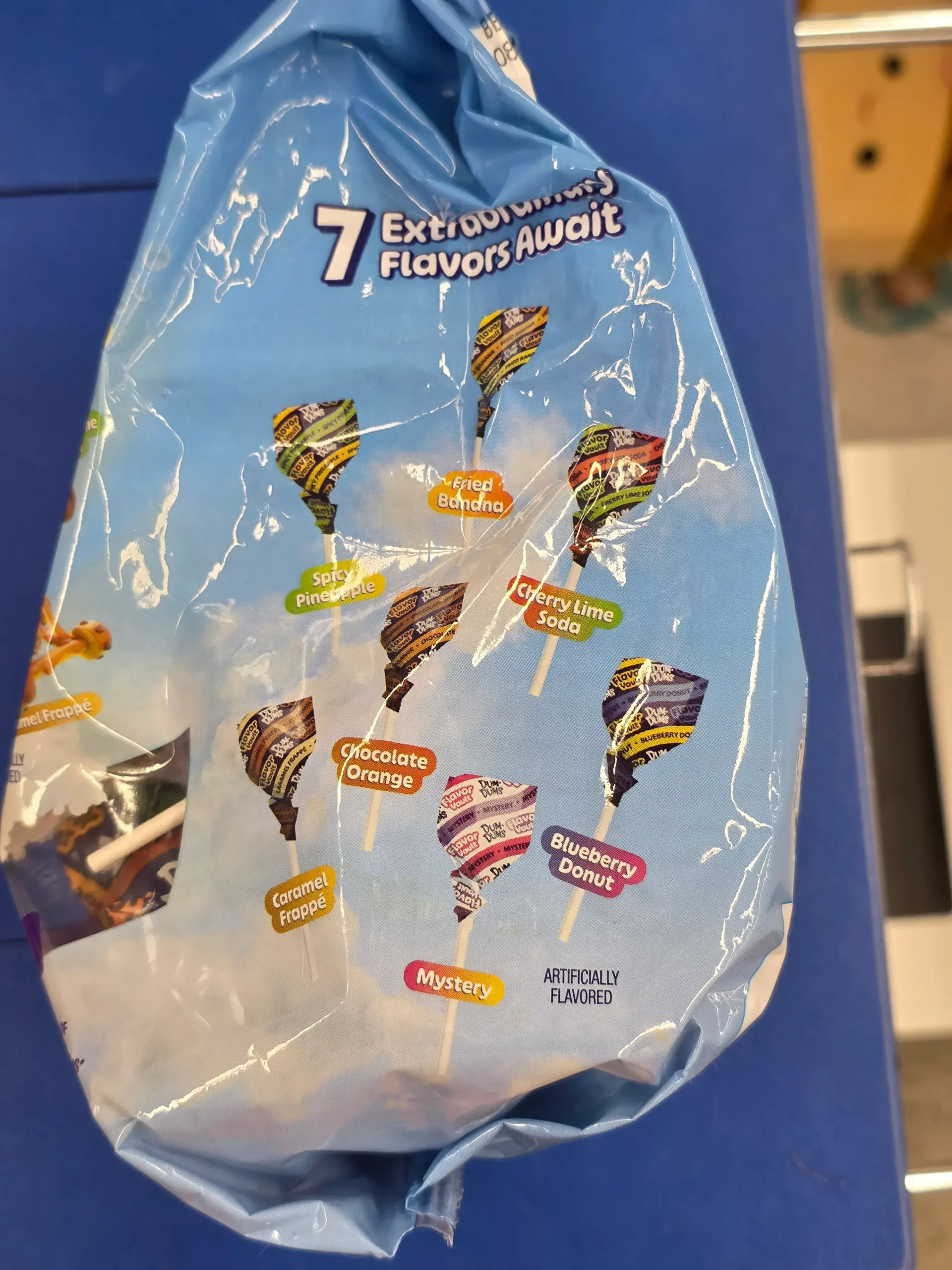 Dum-Dums Flavor Vault: Fried Banana, Cherry Lime Soda, Blueberry Donut, Mystery, Caramel Frappe, Chocolate Orange, and Spicy Pineapple.