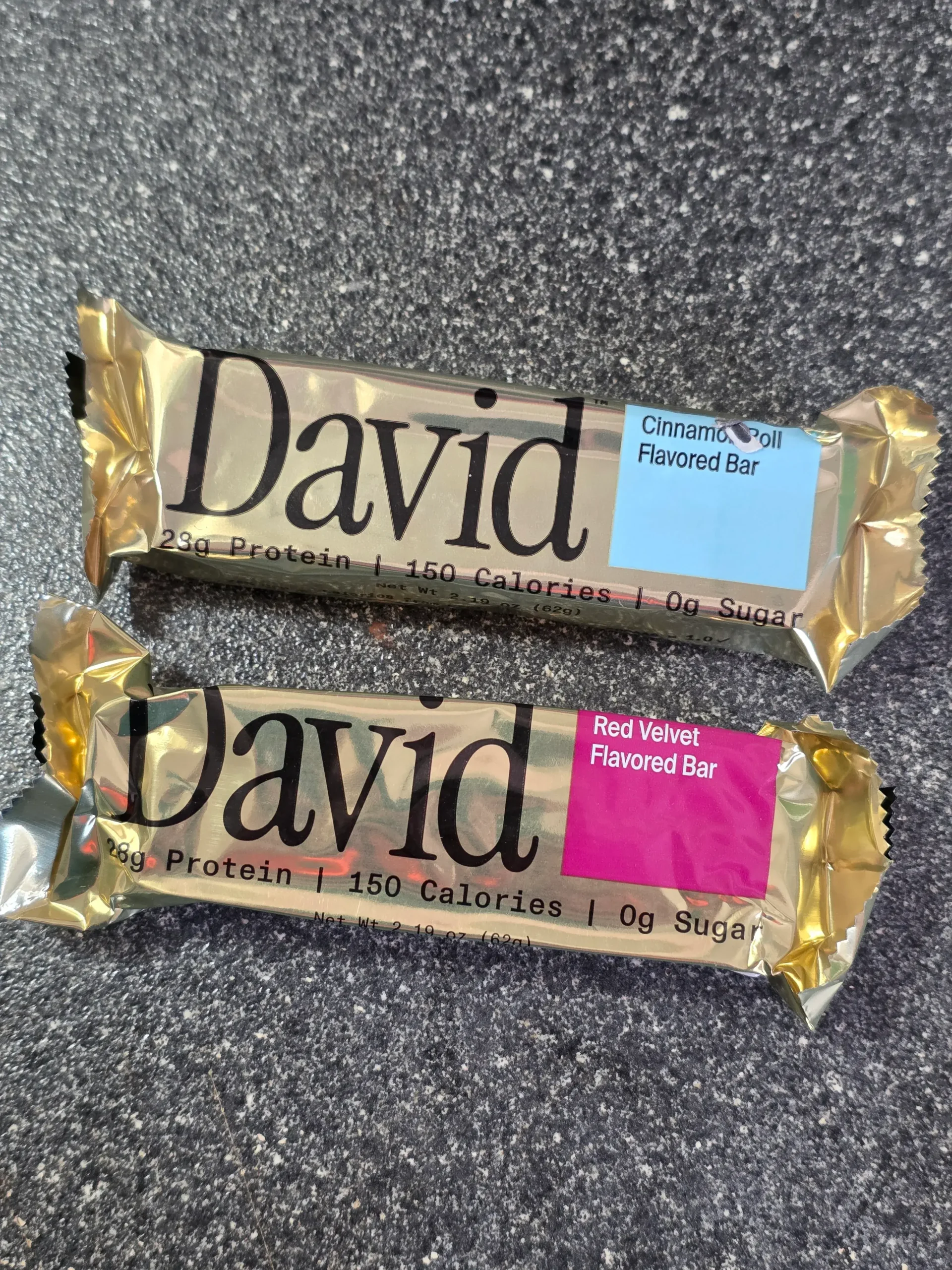 David Protein Bar: Cinnamon Roll, Red Velvet, Fudge Brownie, Cake Batter, Peanut Butter Chocolate Chunk,  Chocolate Chip Cookie Dough, Salted Peanut Butter, and Blueberry Pie.