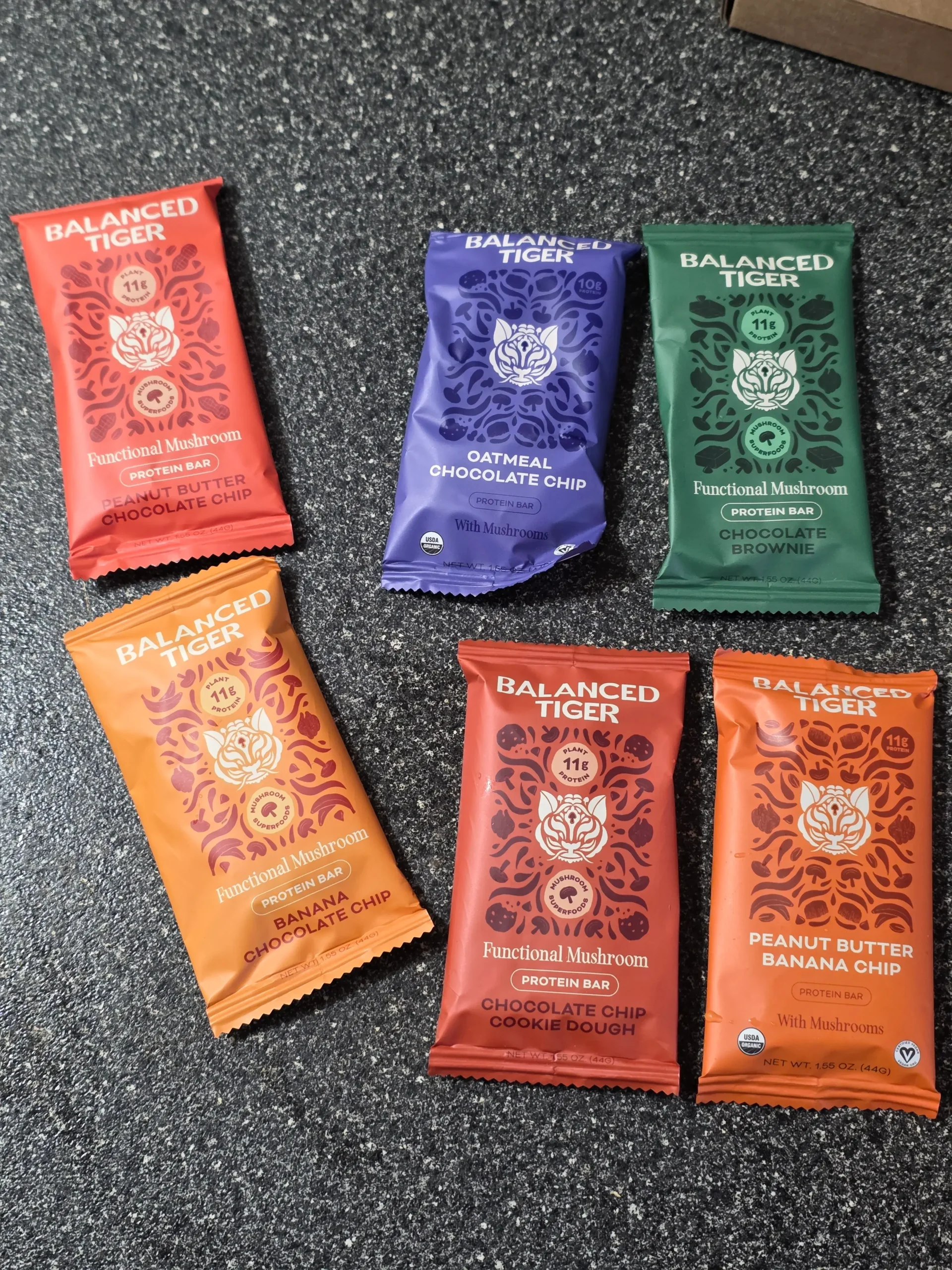 Balanced Tiger Mushroom Protein Bars, Chocolate Brownie, Banana Chocolate Chip, Mint Chocolate Chip, Vanilla Chai, Peanut Butter Chocolate, and Chocolate Chip Cookie Dough.