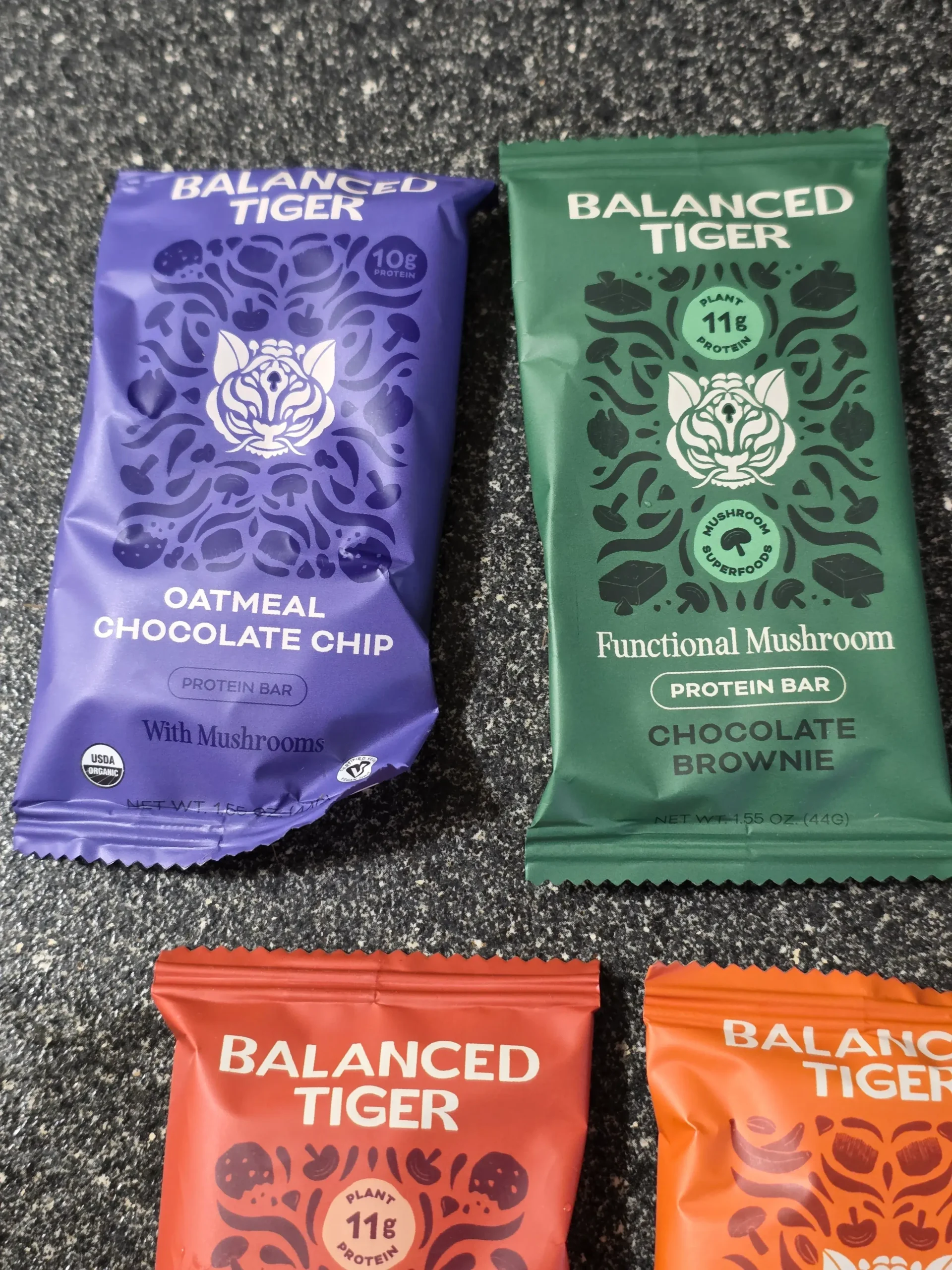 Balanced Tiger Mushroom Protein Bars, Chocolate Brownie, Banana Chocolate Chip, Mint Chocolate Chip, Vanilla Chai, Peanut Butter Chocolate, and Chocolate Chip Cookie Dough.