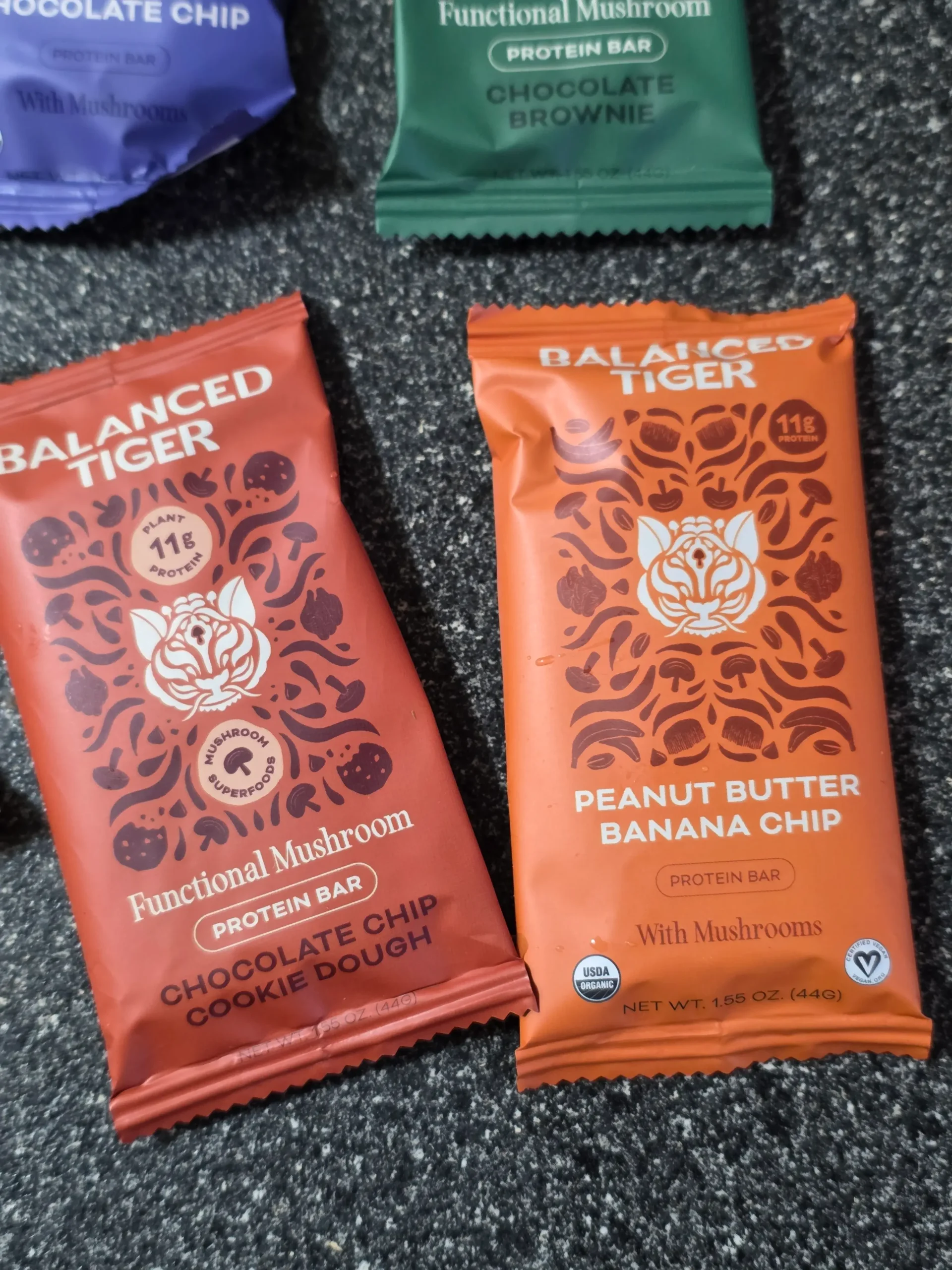 Balanced Tiger Mushroom Protein Bars, Chocolate Brownie, Banana Chocolate Chip, Mint Chocolate Chip, Vanilla Chai, Peanut Butter Chocolate, and Chocolate Chip Cookie Dough.