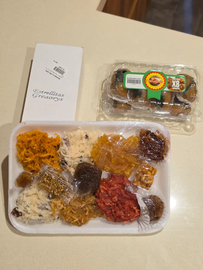 Dulceria el Nino Jesus treats, including: a tray of Orange cocada (coconut and carrot), white cocada, red cocada, candied papaya (or candied cidra), bocadillo (guava paste), sesame brittle (turrón de ajonjolí), tamarind candy, cabello de ángel (candied squash), candied walnut/ pecan, panelita (panela fudge), wrapped panela candy, as well as arequipe with powdered sugar, and brevas con arequipe.